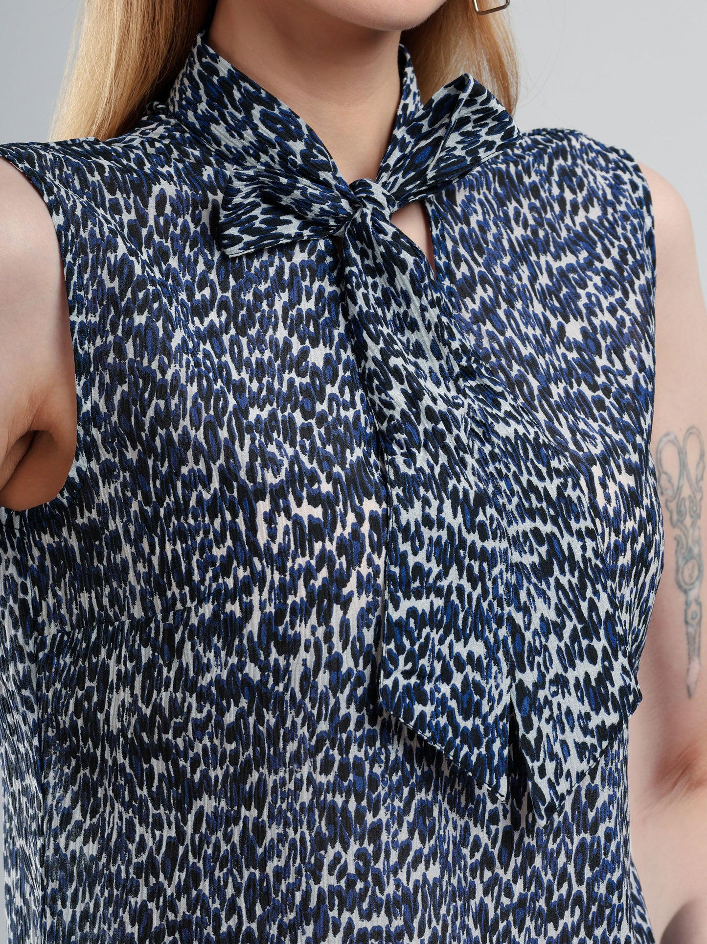 Woman wearing a sleeveless blouse with a patterned design