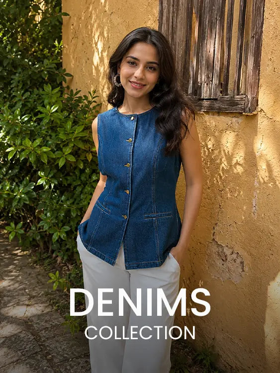 Woman wearing a sleeveless denim top with white trousers in a sunny outdoor courtyard – Cory Edge Women's Denim Collection