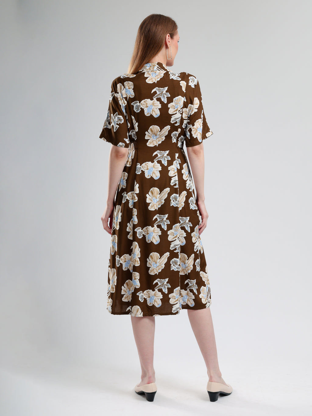 Woman wearing a brown floral dress on a white background