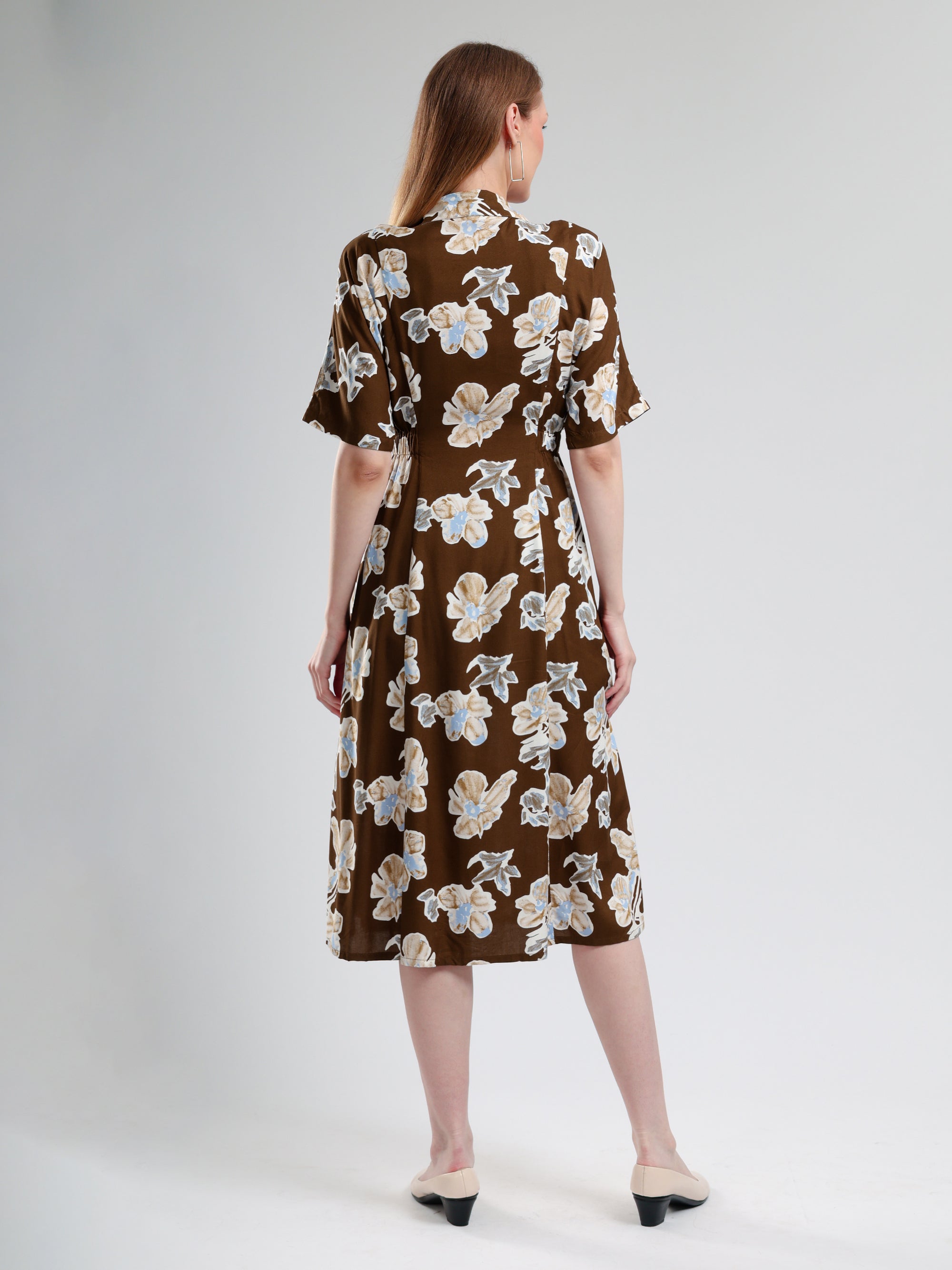 Woman wearing a brown floral dress on a white background