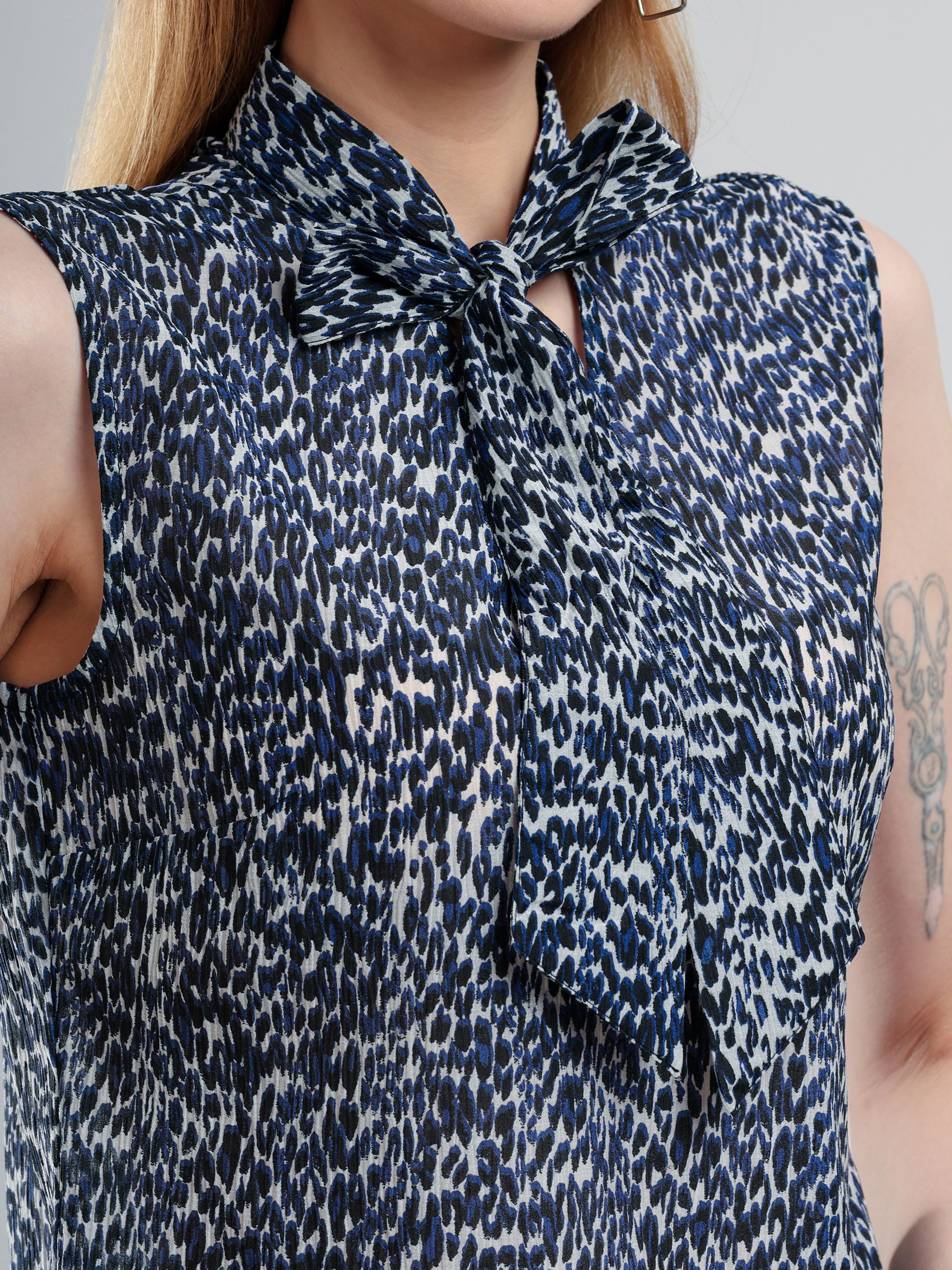 Woman wearing a sleeveless blouse with a patterned design