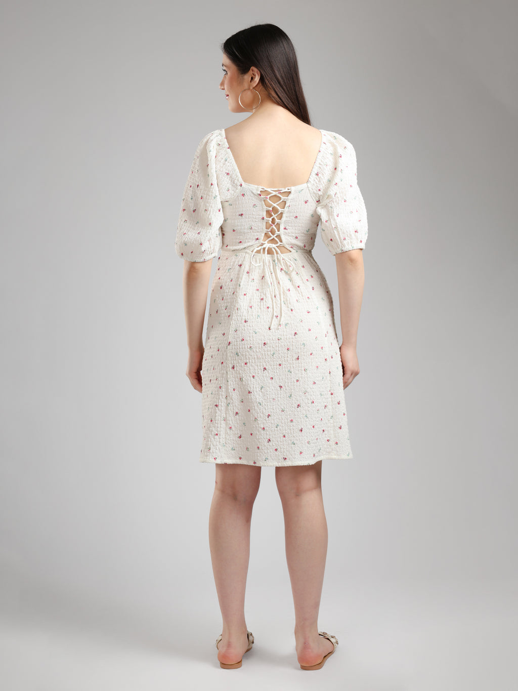 Woman wearing a white floral dress back pose